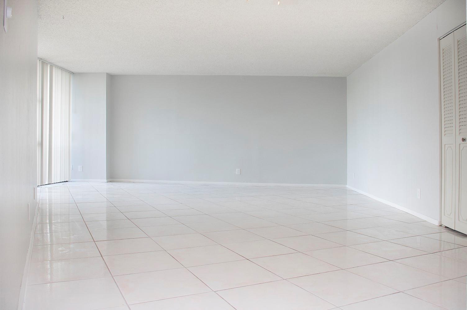 An empty room with white tile flooring, light gray walls, and vertical window blinds — 800 Parkview Drive # 411, Hallandale Beach FL 33009, HALLANDALE BEACH, FL