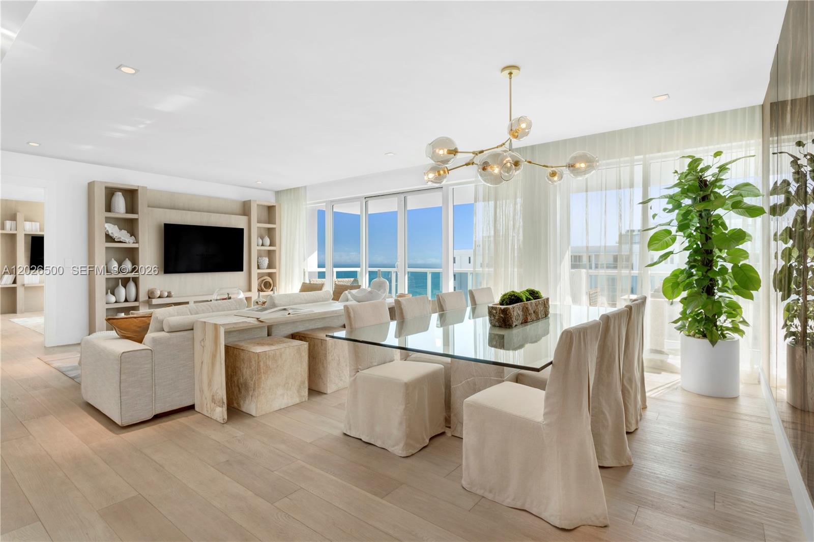 A bright, open-concept living and dining area features light wood floors, neutral furniture, and ocean views — 102 24th St # 1706, Miami Beach FL 33139, MIAMI BEACH, FL