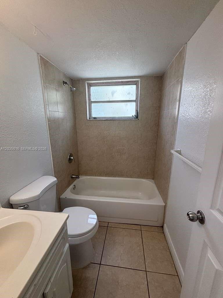 A bathroom features a white toilet, a vanity, and a tiled bathtub shower combination — 8275 NE Miami Ct # 202, Miami FL 33138, MIAMI, FL