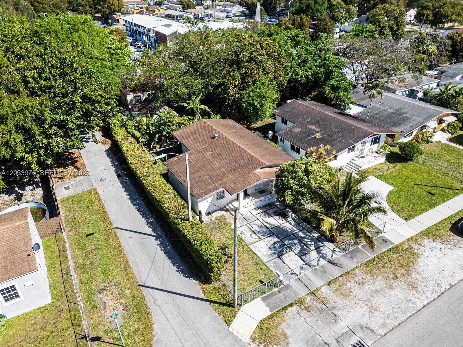 An aerial view shows a single-story house with a brown roof and a paved driveway — 1243 NW 42nd St, Miami FL 33142, MIAMI, FL
