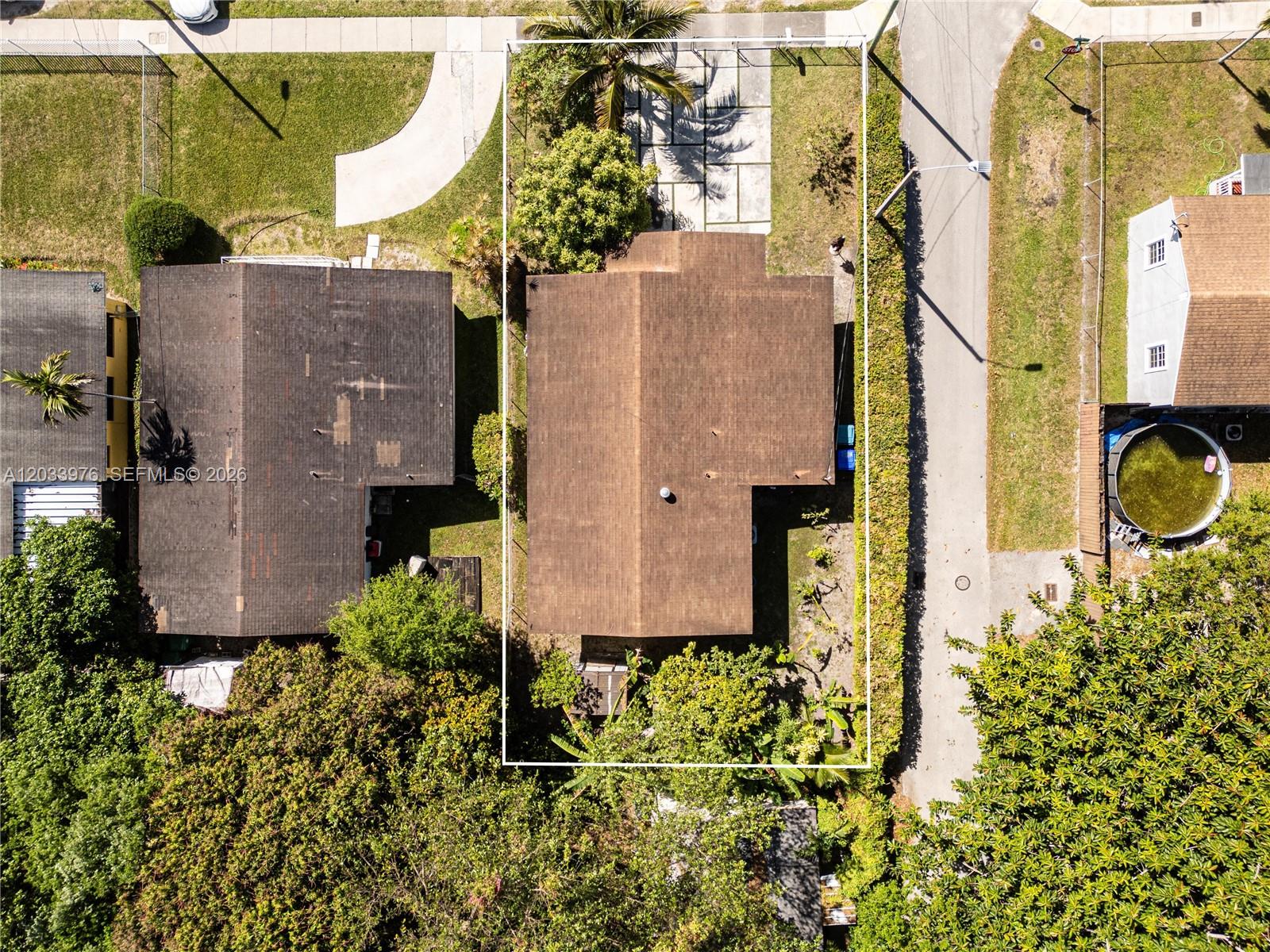 An aerial view shows a house with a brown roof and a paved driveway — 1243 NW 42nd St, Miami FL 33142, MIAMI, FL