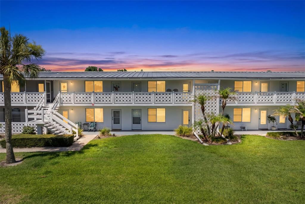 A two-story apartment building with a white exterior, metal roof, and a grassy lawn — 1140 S ORLANDO AVENUE UNIT H3, MAITLAND, FL