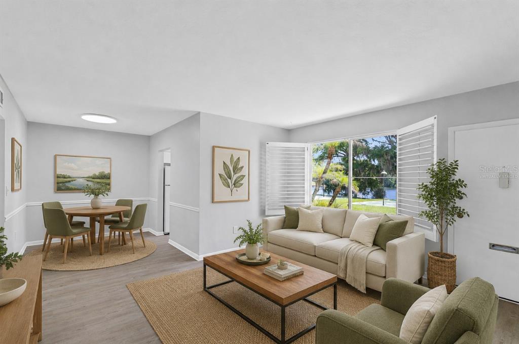This virtually staged living and dining area features light wood floors and a lake view — 1140 S ORLANDO AVENUE UNIT H3, MAITLAND, FL
