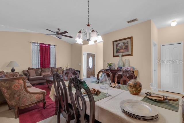 A dining room with a table and chairs sits adjacent to a living area — 5120 SHALE RIDGE TRAIL, ORLANDO, FL