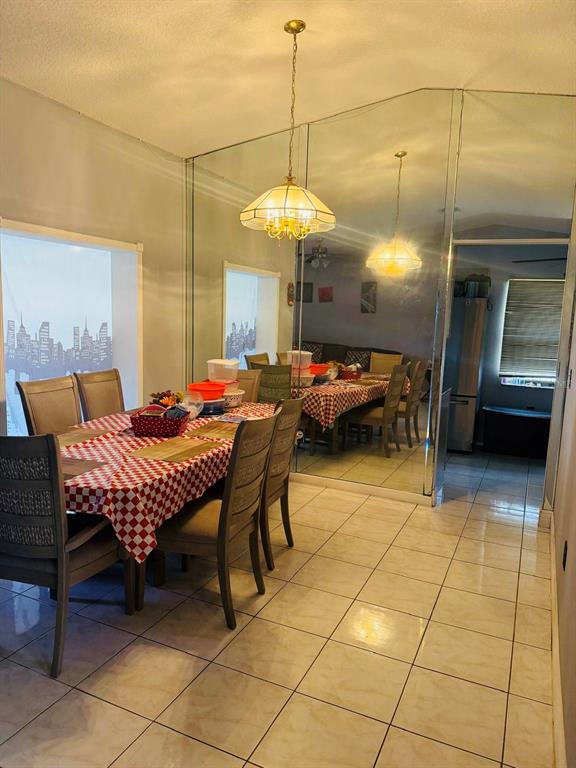 A dining room features a checkered tablecloth, a hanging light fixture, and a mirrored wall — 2910 VIENNA LANE, KISSIMMEE, FL
