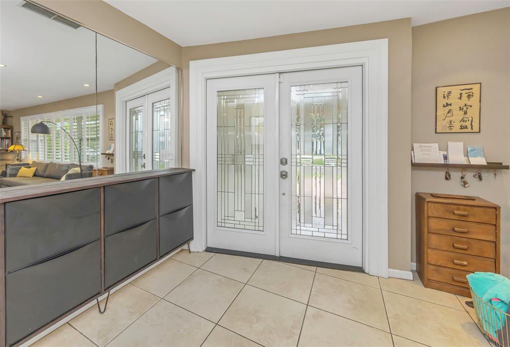 An entryway features tiled floors, a double glass-paneled front door, and a dark storage cabinet — 4313 50TH PLACE S, ST PETERSBURG, FL