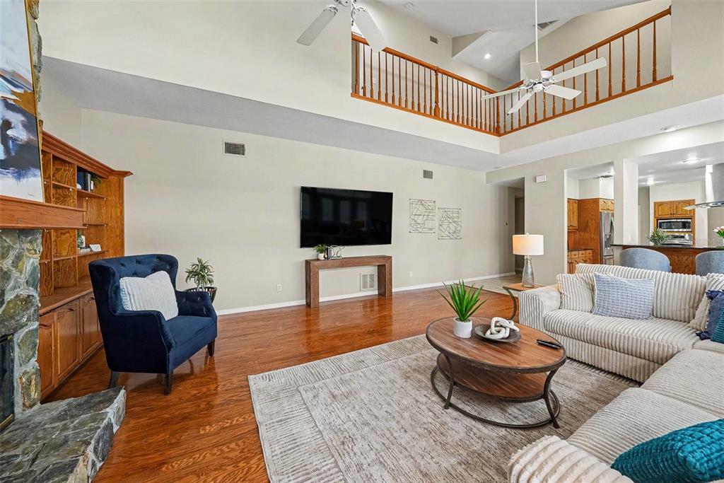 A living room with hardwood floors, a stone fireplace, and a high vaulted ceiling — 833 MARCO DRIVE NE, ST PETERSBURG, FL