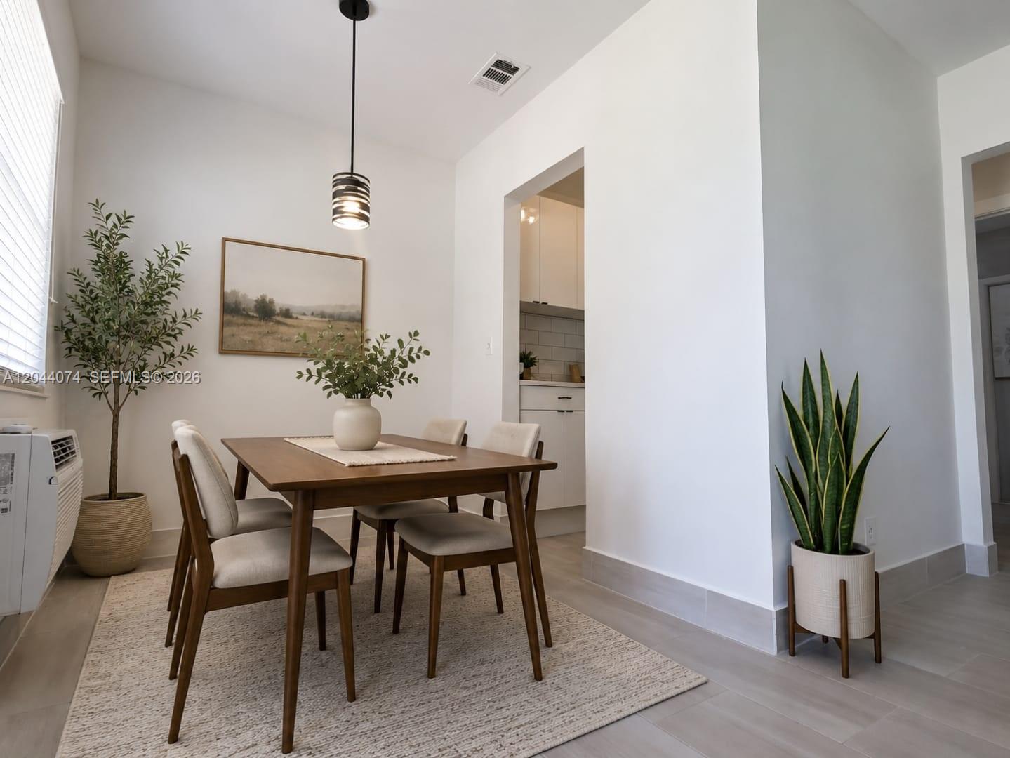 A dining area features a wooden table, four upholstered chairs, and two potted plants — 120 NE 10th Ave # 3, Hallandale Beach FL 33009, HALLANDALE BEACH, FL