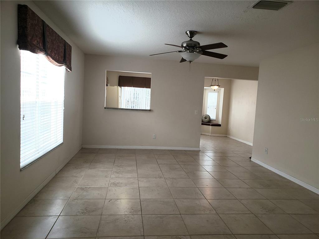 A single-story house with a beige stucco exterior, a two-car garage, and a concrete driveway — 10310 LAKESIDE VISTA DRIVE, RIVERVIEW, FL