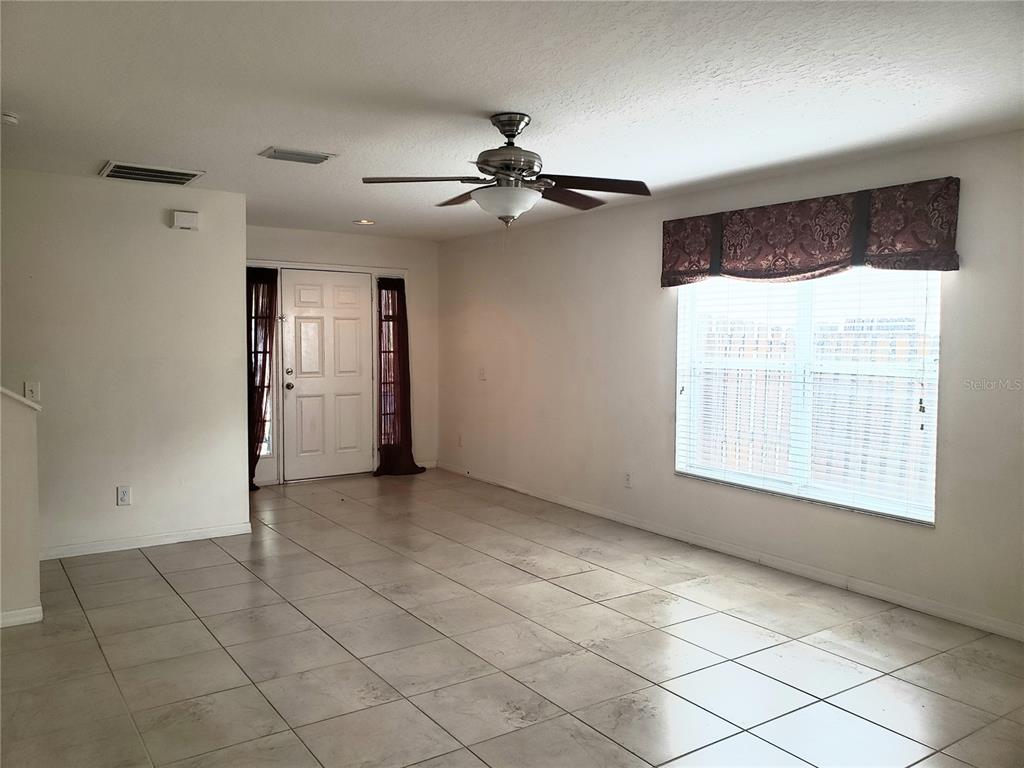 An entryway features a white front door with sidelights, a side door, and tiled flooring — 10310 LAKESIDE VISTA DRIVE, RIVERVIEW, FL