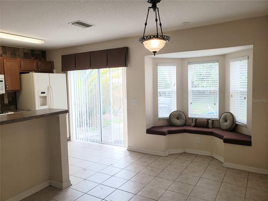 A living room with tile flooring, a ceiling fan, and a pass-through to the kitchen — 10310 LAKESIDE VISTA DRIVE, RIVERVIEW, FL