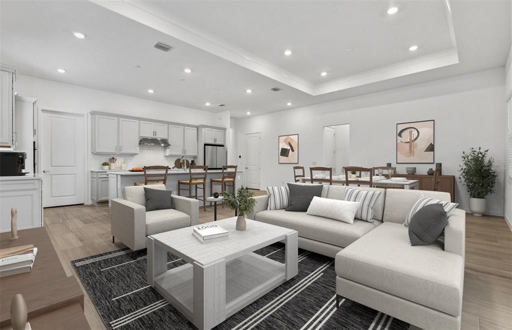 This is a digitally staged open-concept living room and kitchen with light-colored furniture and cabinetry — 13630 CANYON RIDGE ROAD, SPRING HILL, FL