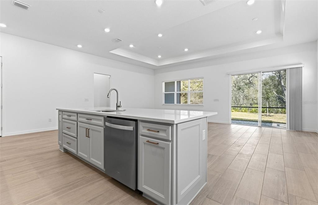 A kitchen island with a stainless steel dishwasher sits in a room with light flooring — 13630 CANYON RIDGE ROAD, SPRING HILL, FL
