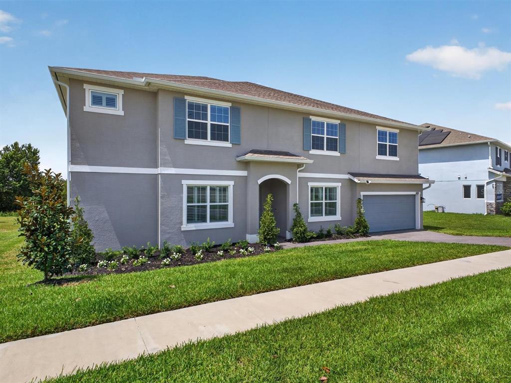A two-story gray house with a two-car garage and a front lawn — 603 AVILA PLACE, HOWEY IN THE HILLS, FL