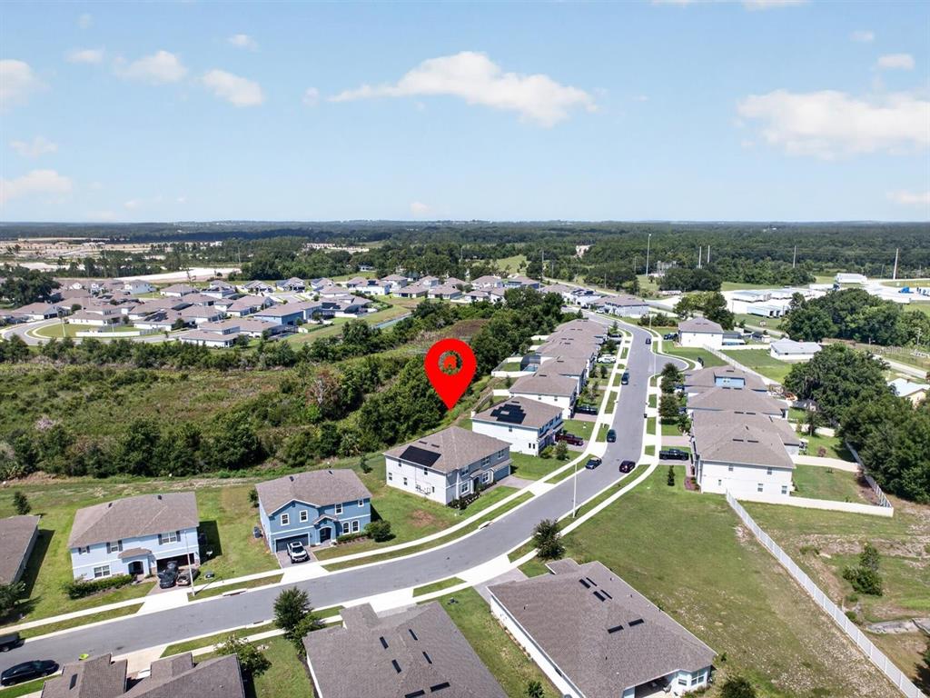 An aerial view shows a suburban neighborhood with a red location pin over a lot — 603 AVILA PLACE, HOWEY IN THE HILLS, FL