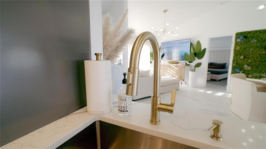 A close-up view of a kitchen sink faucet with a white marble countertop — 18770 MCGRATH CIRCLE, PORT CHARLOTTE, FL