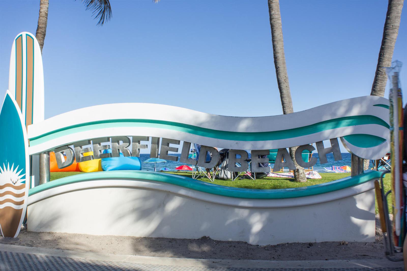 A white sign with teal accents reads Deerfield Beach in front of a grassy area — 1955 NE 4th Street Unit 2, Deerfield Beach FL 33441, DEERFIELD BEACH, FL