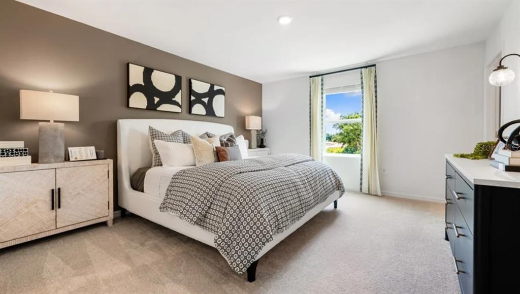 A bedroom features a white upholstered bed, a brown accent wall, and two dressers — 10782 ECLIPSE STREET, SARASOTA, FL