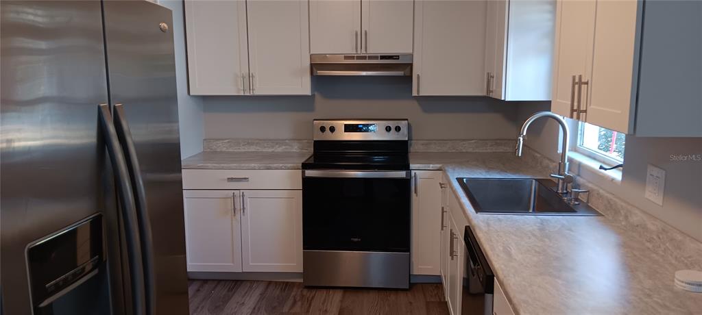 A stainless steel kitchen sink with a faucet and soap dispenser set in laminate countertops — 1440 SE 23RD AVENUE, GAINESVILLE, FL
