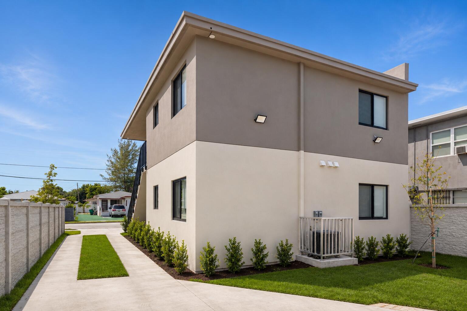 A two-story building with a two-tone exterior, concrete driveway, and small landscaping in the yard — 1181 NW 66th Street # 1181, Miami FL 33150, MIAMI, FL