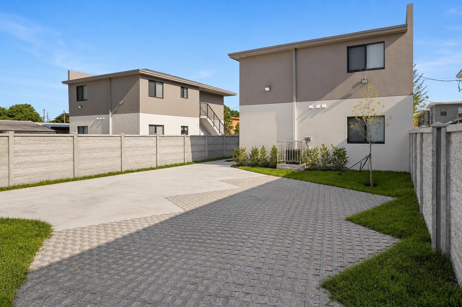 A paved driveway sits between two modern two-story buildings enclosed by a concrete fence — 1181 NW 66th Street # 1181, Miami FL 33150, MIAMI, FL