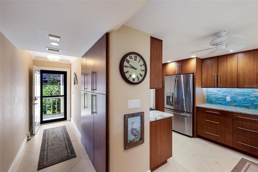 A kitchen with wood cabinets, stainless steel appliances, and a blue tile backsplash — 5757 GULF OF MEXICO DRIVE UNIT 205, LONGBOAT KEY, FL