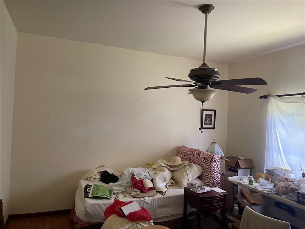 A bedroom features a ceiling fan, a bed with a patterned headboard, and a desk — 809 W PIPKIN ROAD, LAKELAND, FL