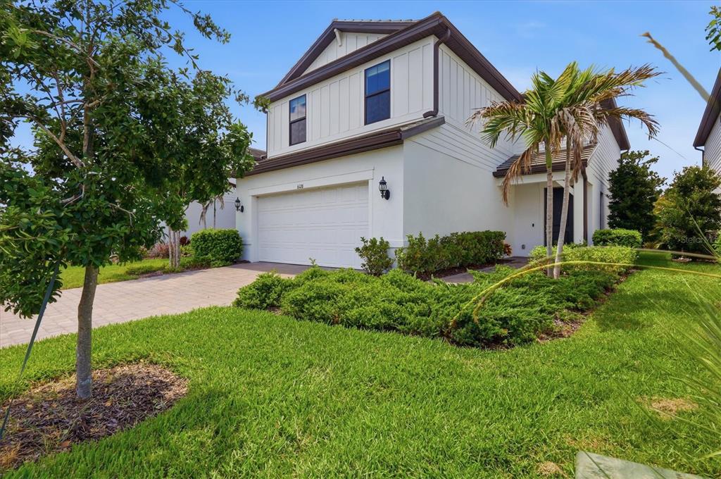 A two-story house with a white exterior, a two-car garage, and a paved driveway — 6126 BLUESTAR COURT, LAKEWOOD RANCH, FL