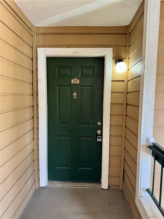 A dark green front door with a brass knocker and number plate 207 — 5533 CHRISHIRE WAY UNIT F207, ORLANDO, FL