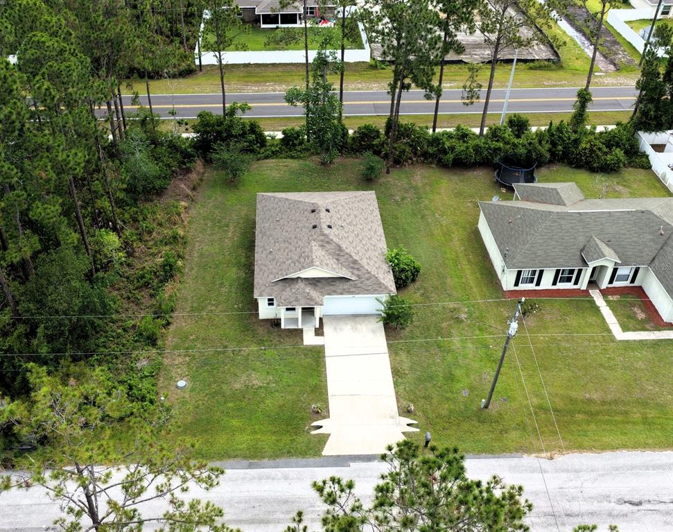 An aerial view shows a single-story house with a concrete driveway and a large yard — 173 RYBERRY DRIVE, PALM COAST, FL