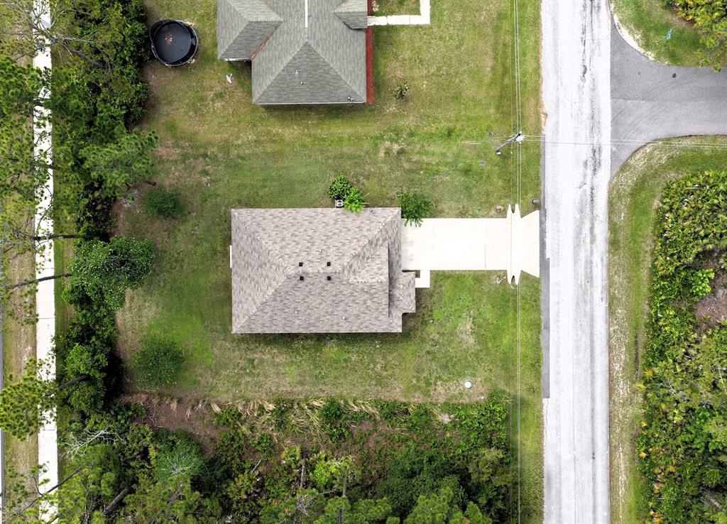 An aerial view shows a single-story house with a driveway and a large grassy yard — 173 RYBERRY DRIVE, PALM COAST, FL