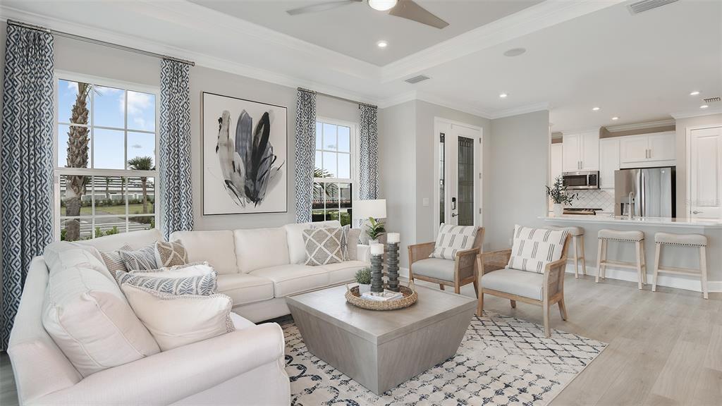 A living room features a white sofa, two armchairs, a coffee table, and an open kitchen — 10251 MORNING MIST LANE, SARASOTA, FL