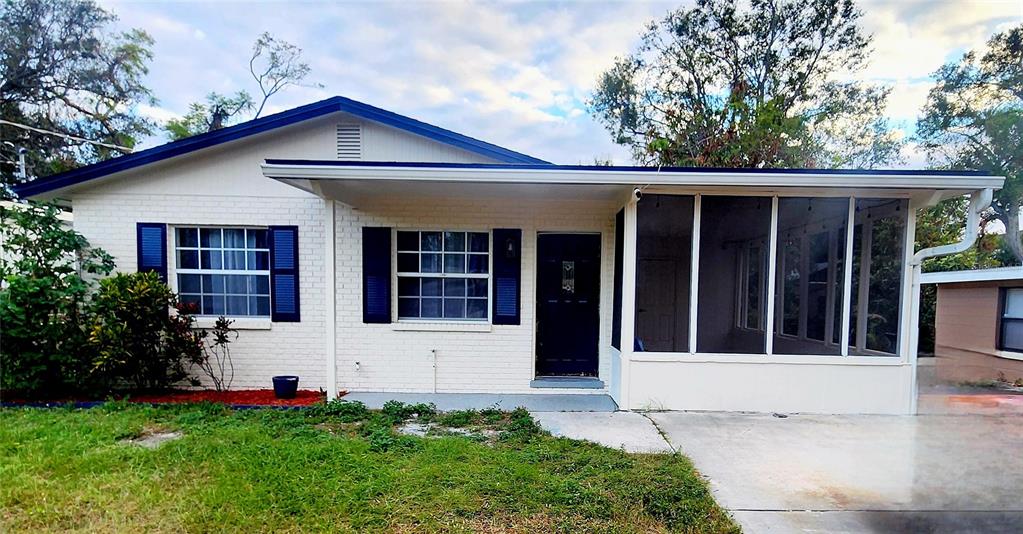 A single-story white brick house features a screened-in porch and a concrete driveway — 4306 W LA SALLE STREET, TAMPA, FL