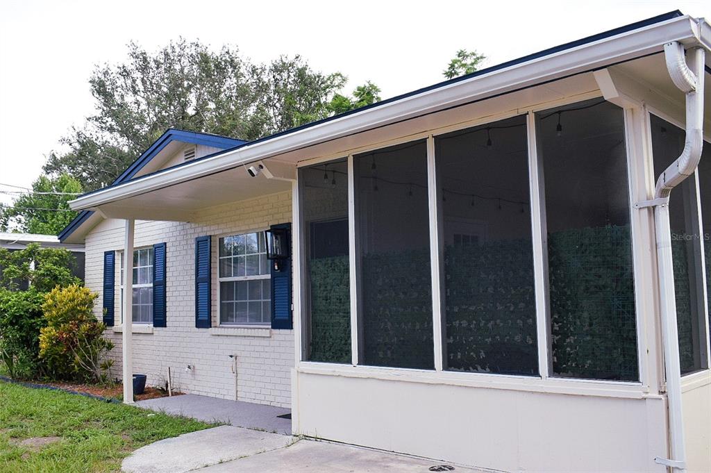A white brick house features blue shutters and an attached screened-in porch — 4306 W LA SALLE STREET, TAMPA, FL