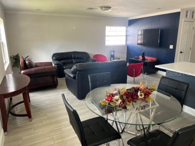 A living and dining area features tile flooring, a dark blue accent wall, and leather furniture — 4306 W LA SALLE STREET, TAMPA, FL