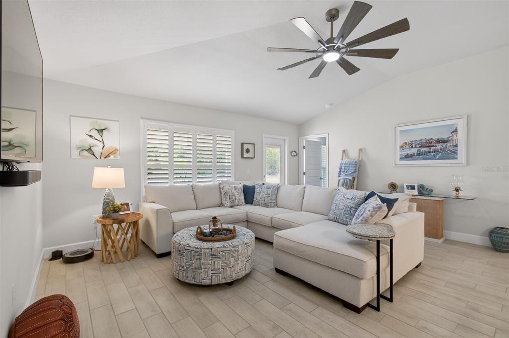 A living room features a large sectional sofa, a round ottoman, and a ceiling fan — 25013 SW 24TH PLACE, NEWBERRY, FL