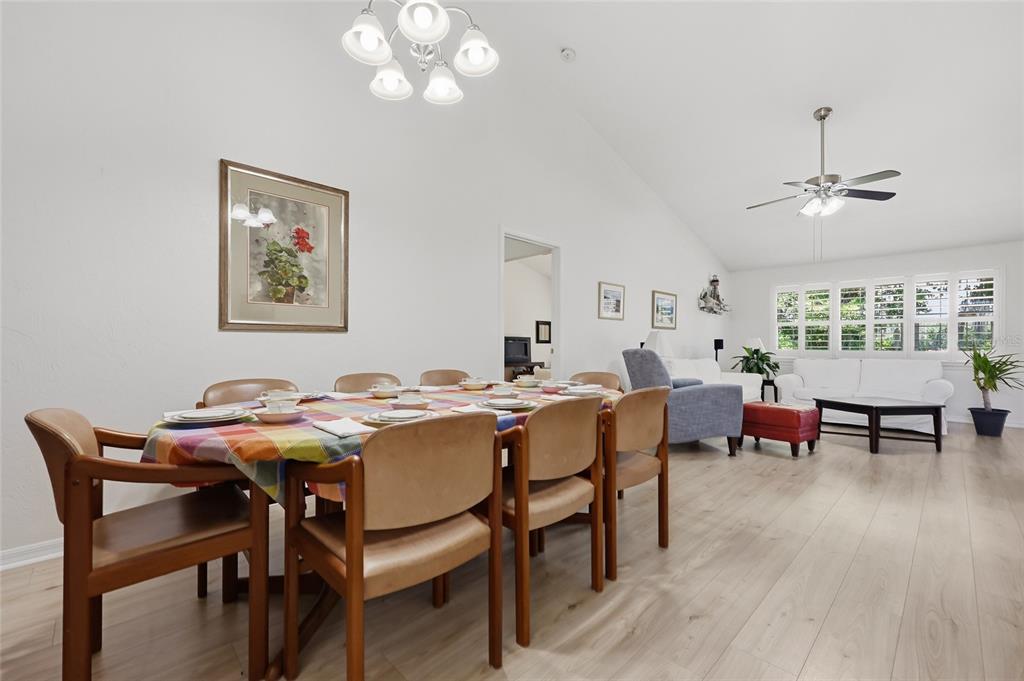 A dining area with a wooden table and chairs sits in an open-concept living space — 10530 NW 36TH LANE, GAINESVILLE, FL