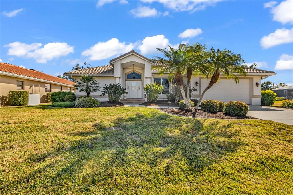 A single-story house with a beige exterior, a tiled roof, and a front-facing garage — 3518 TERIN COURT, PUNTA GORDA, FL