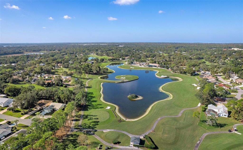 An aerial view shows a large lake surrounded by a golf course and residential homes — 6409 WEDGEWOOD DRIVE, SPRING HILL, FL