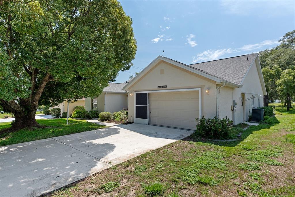 A beige house with a single-car garage and a large tree in the front yard — 978 W COLBERT COURT, BEVERLY HILLS, FL