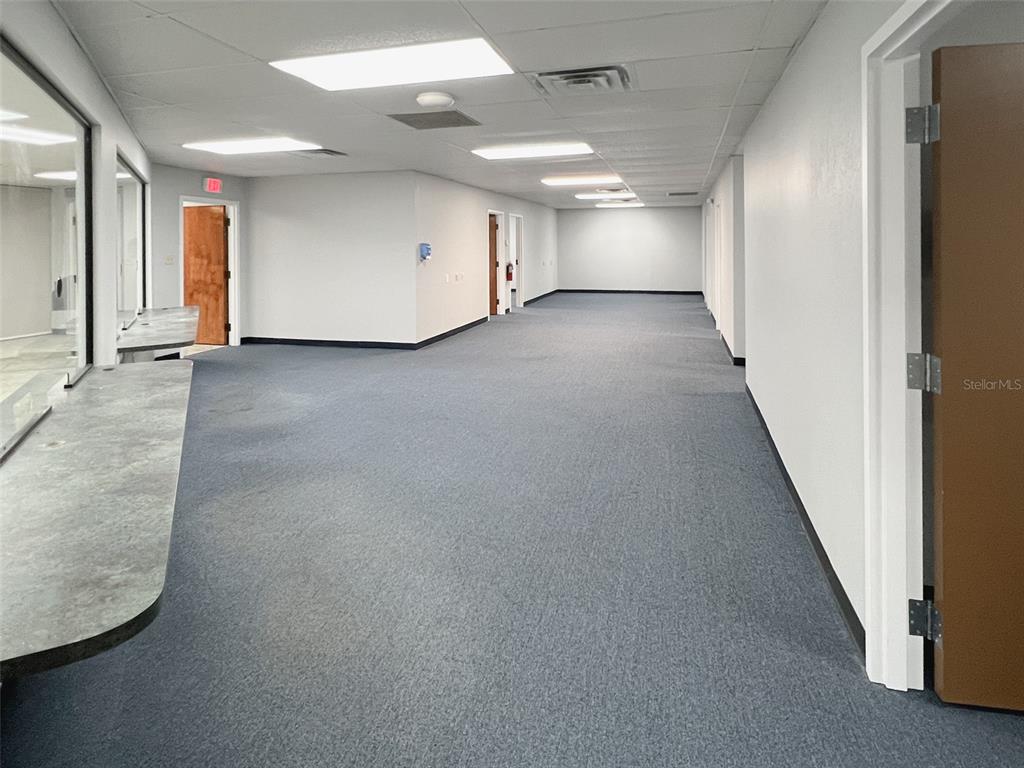 An empty office hallway features gray carpeting, white walls, and a service counter — 500 W LAKE MARY BOULEVARD UNIT 536, SANFORD, FL
