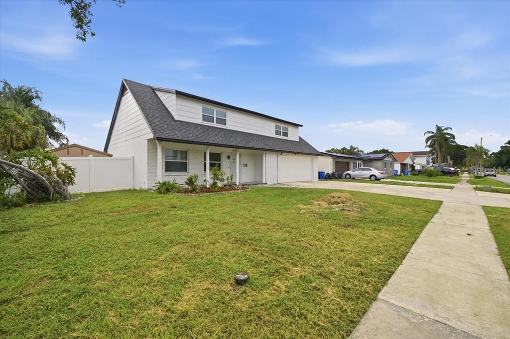 An open-concept living and dining area features a wood-accented kitchen island and tile flooring — 4710 TRAVERTINE DRIVE, TAMPA, FL