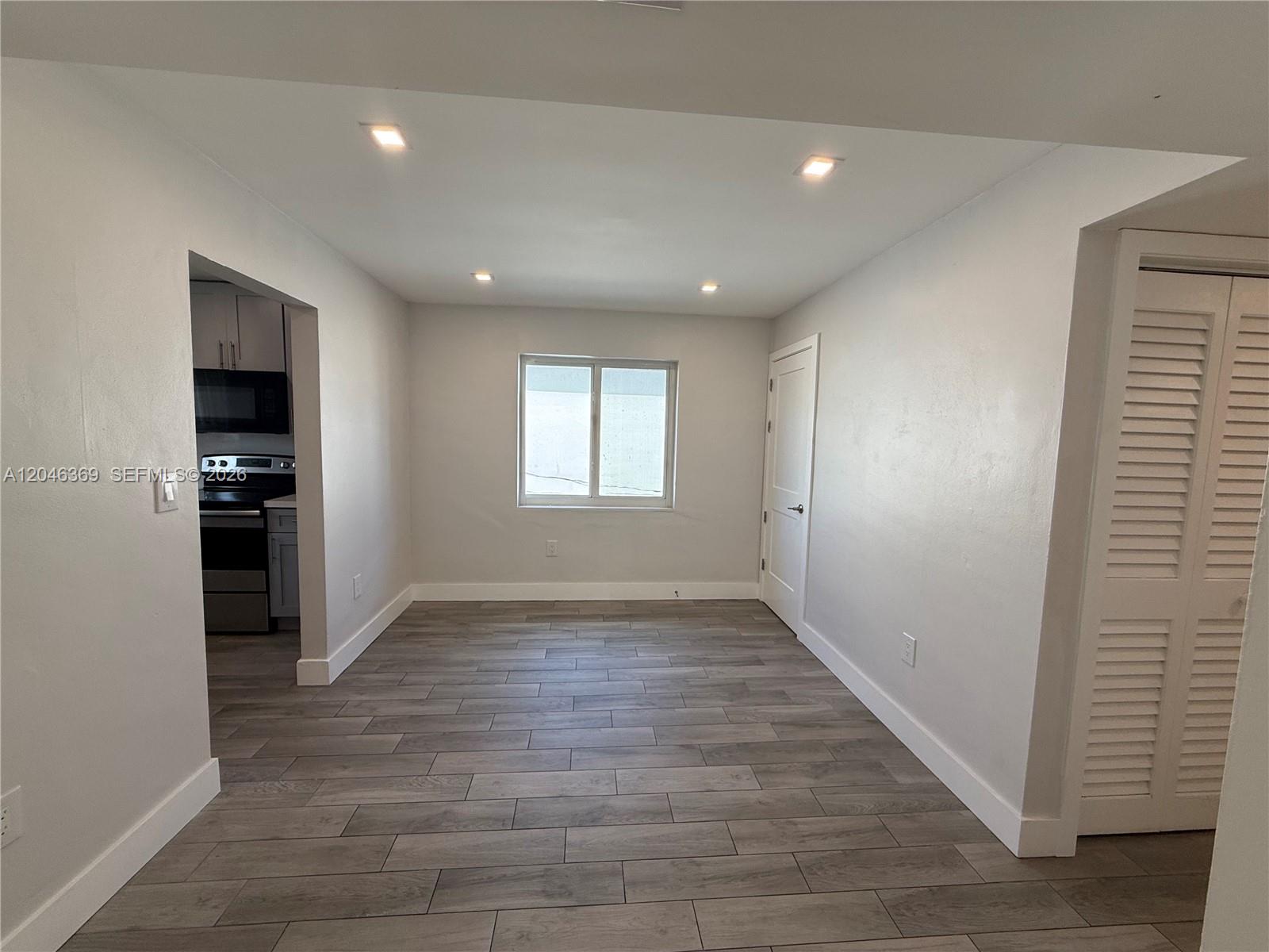 A dining area with gray wood-look tile flooring, recessed lighting, and a white door — 12th Street SE 12th St # 837, Hialeah FL 33010, HIALEAH, FL
