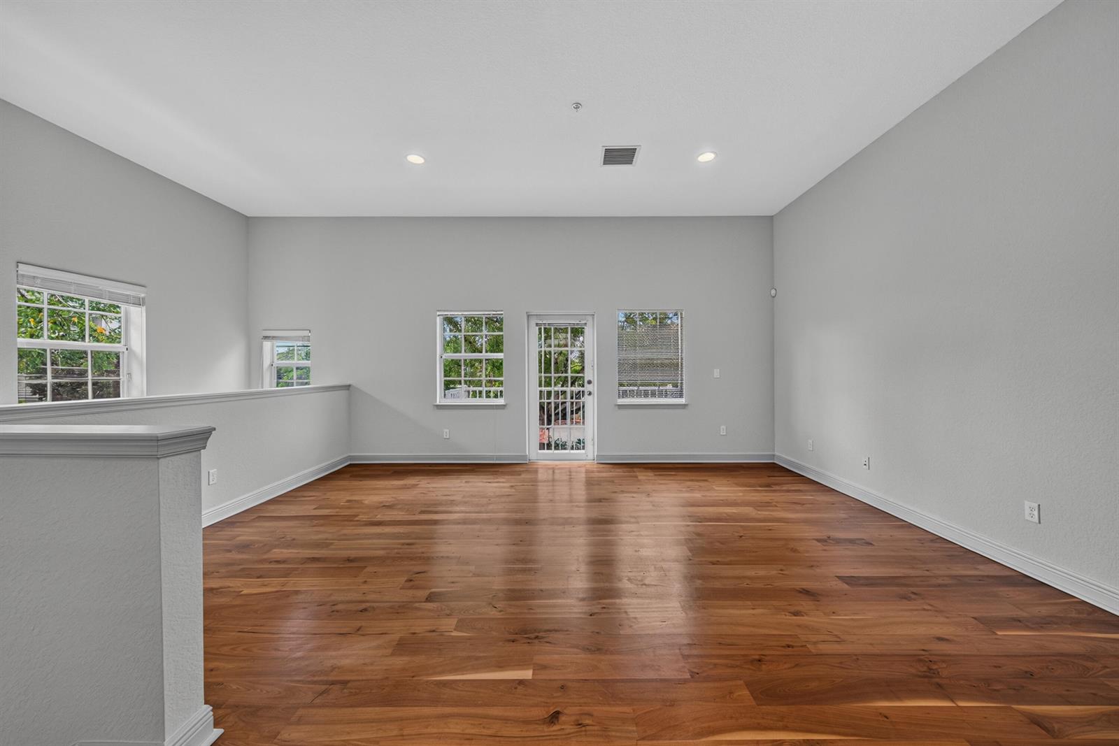 An empty room with hardwood floors, light gray walls, and a balcony door — 2700 NE 8th Avenue, Wilton Manors FL 33334, WILTON MANORS, FL