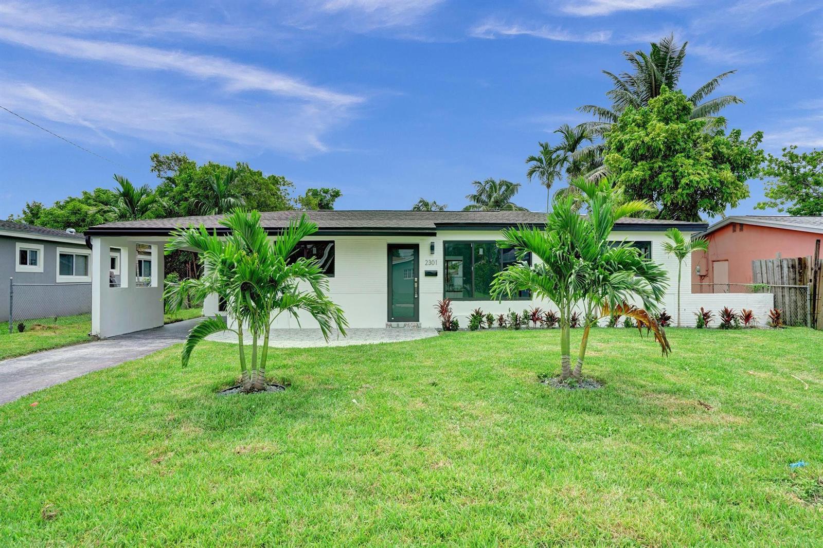 A single-story white house with a carport, front lawn, and two small palm trees — 2301 Alcazar Drive, Miramar FL 33023, MIRAMAR, FL