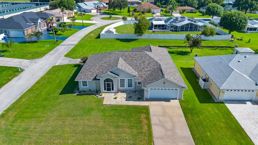 An aerial view shows a single-story suburban house with a shingled roof and driveway — 2326 JACKSON DRIVE, SEBRING, FL