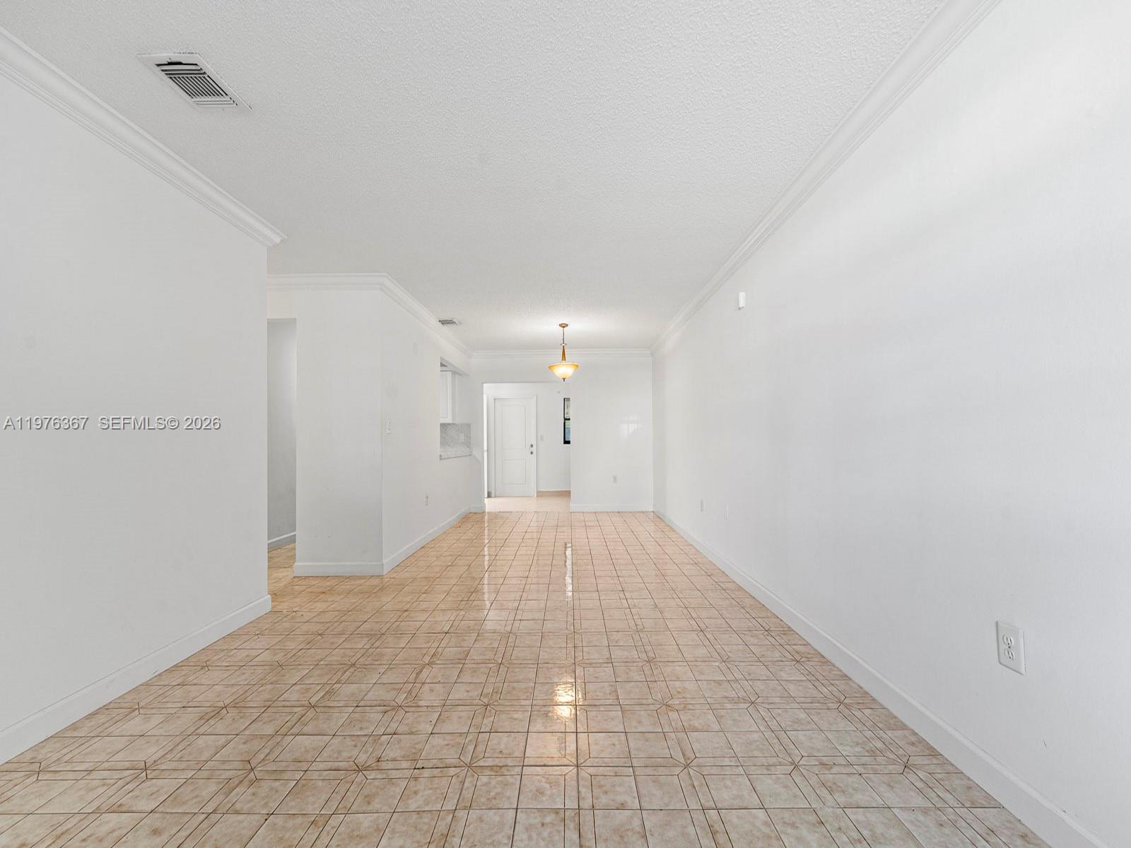 An empty room features white walls, a textured ceiling, and light-colored square floor tiles — 7121 SW 102nd Ct, Miami FL 33173, MIAMI, FL