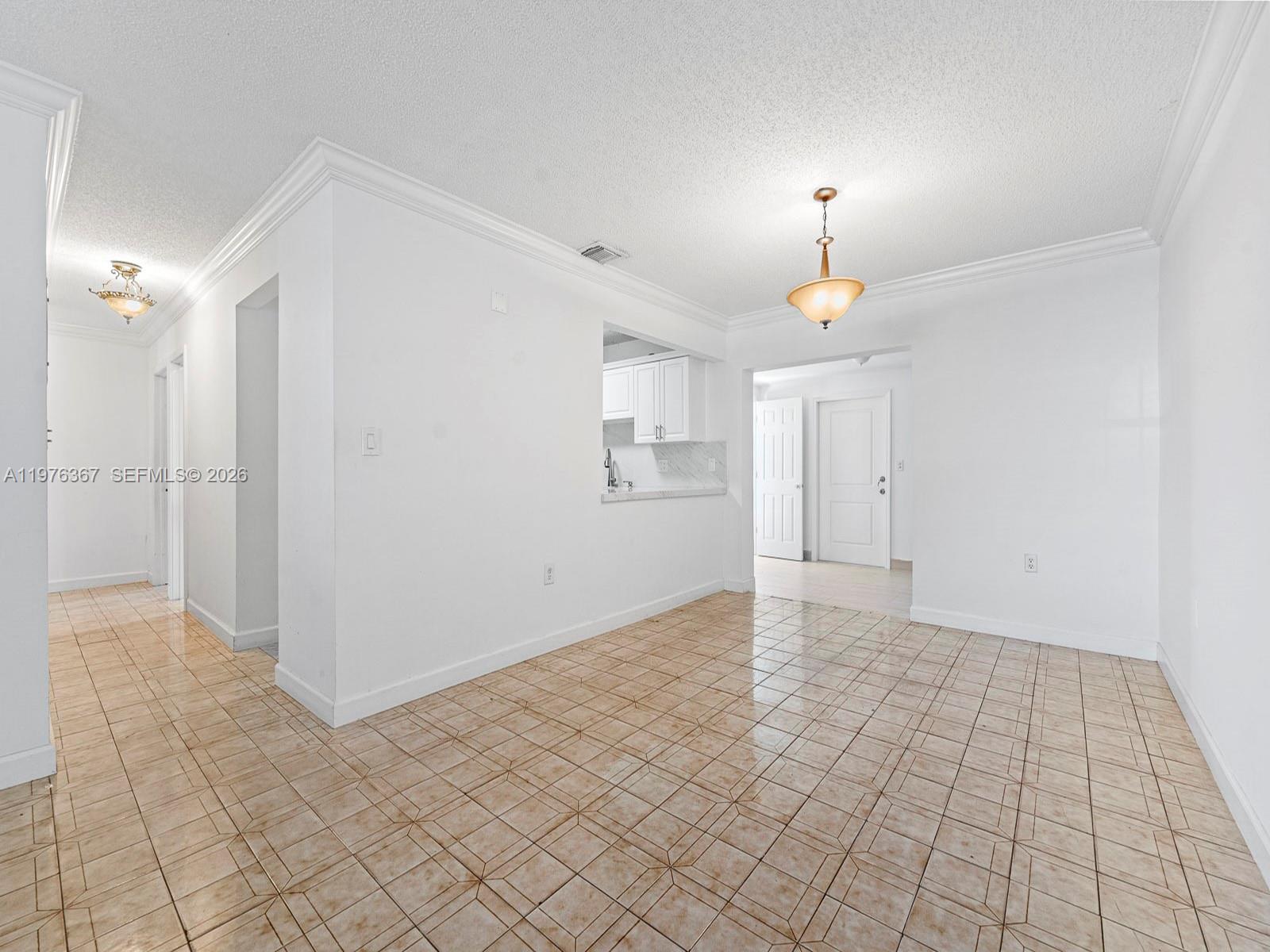 A dining area with beige tile flooring, white walls, and a pass-through to the kitchen — 7121 SW 102nd Ct, Miami FL 33173, MIAMI, FL