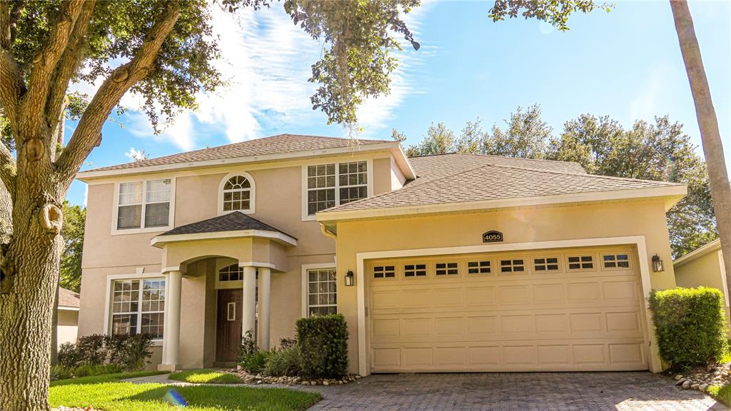 A two-story beige house with a two-car garage and a covered front entryway — 4055 BEACON RIDGE WAY, CLERMONT, FL