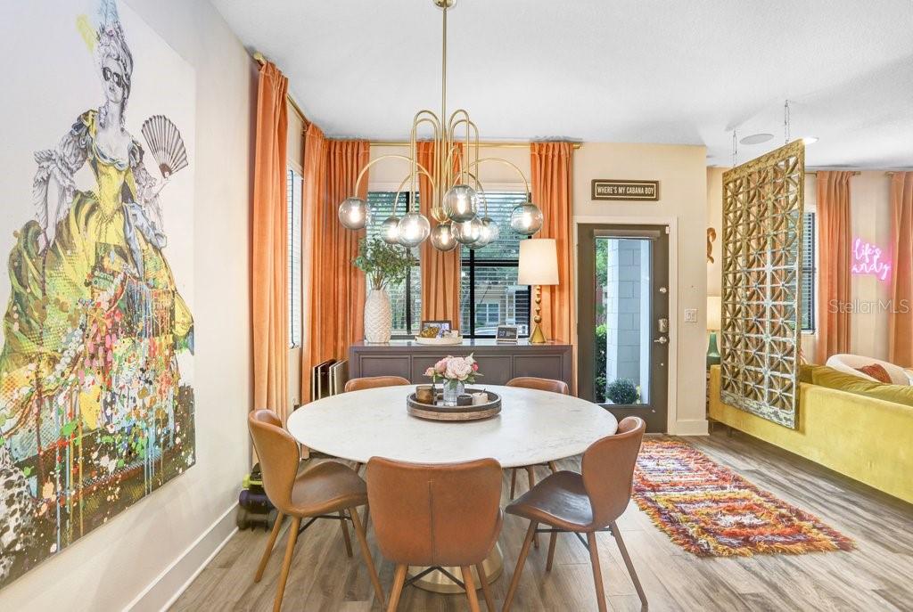 A dining room features a round marble table, mid-century modern chairs, and a gold chandelier — 1210 25TH STREET N, ST PETERSBURG, FL